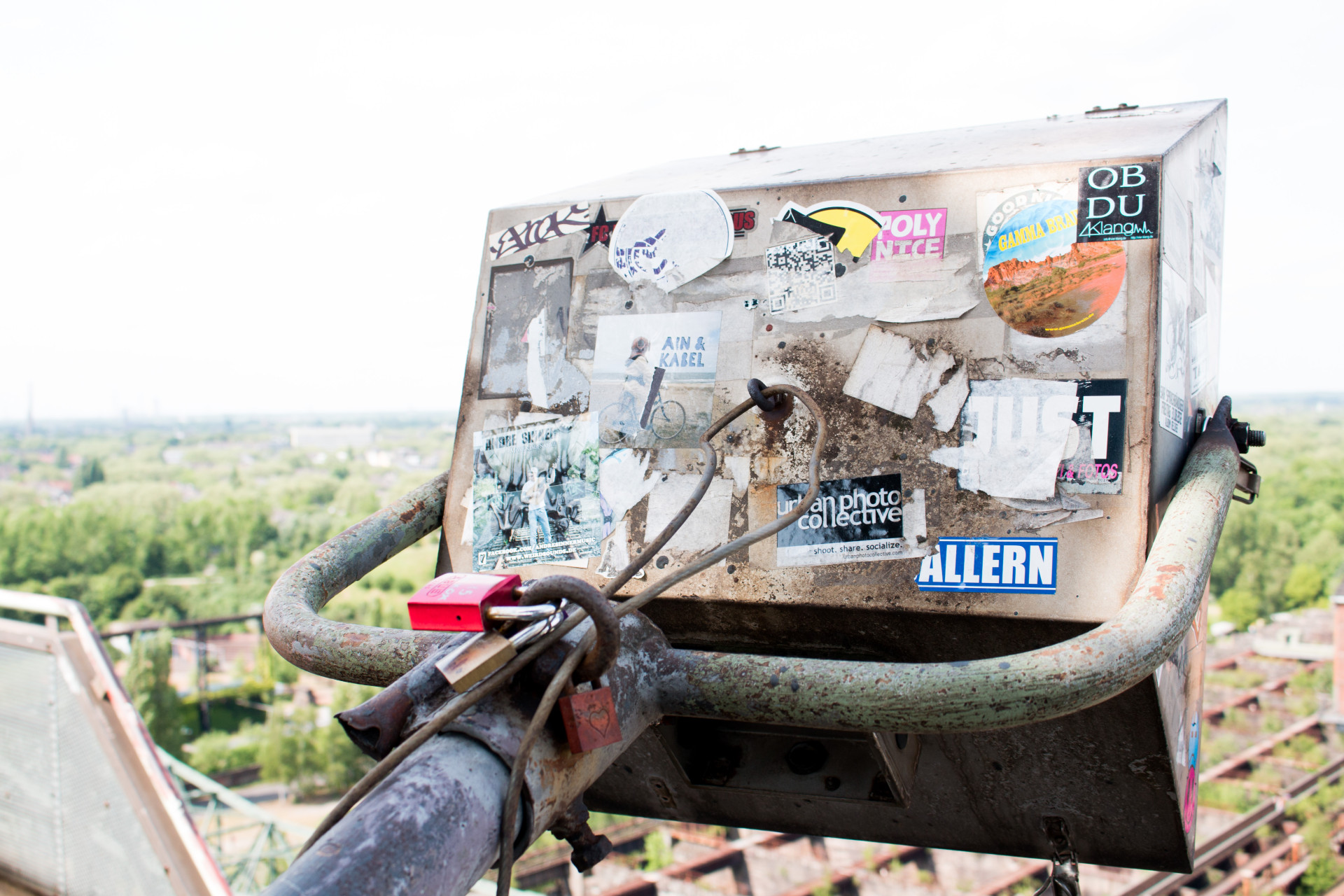 Sticker-Covered Metal Box Overlooking Landscape